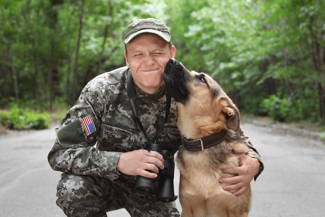 a soldier being nuzzled by a dog
