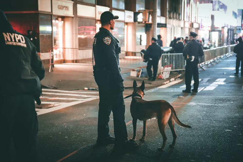 a nypd officer standing with a dog