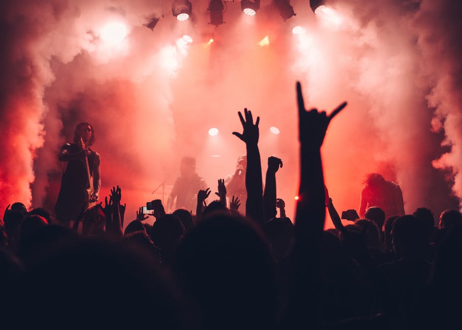 a crowd at a concert with their hands in the air